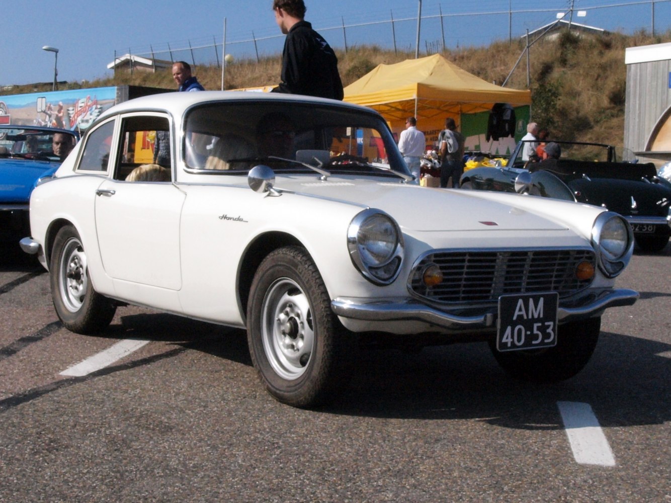 Vintage car front grille with round headlights.