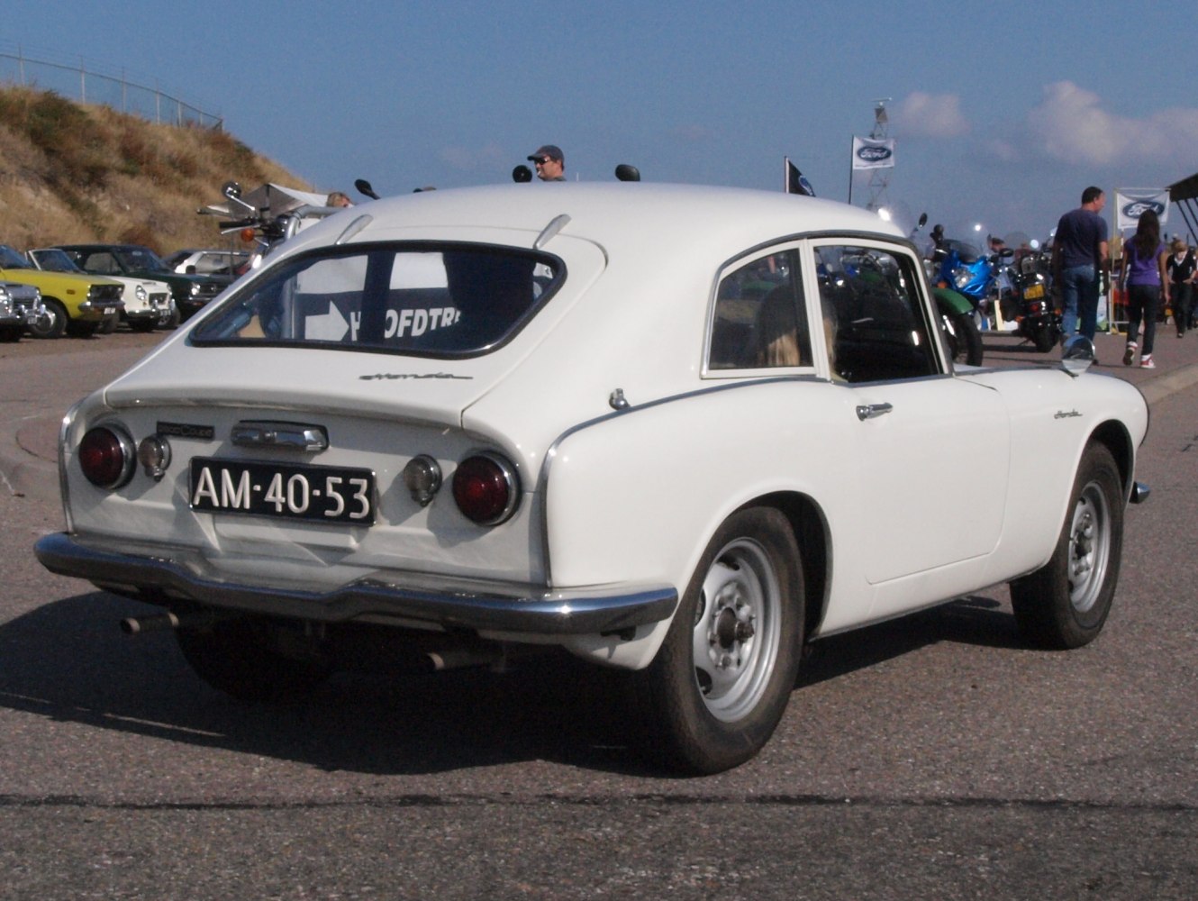 Rear view of a vintage compact coupe with round taillights and curved roofline