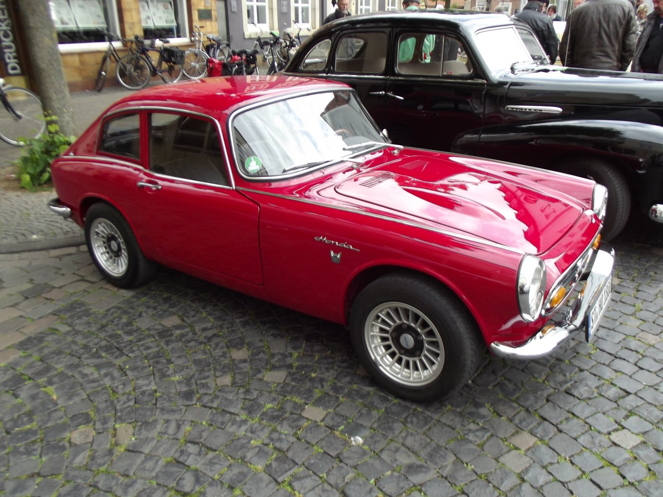 Vintage coupe with round headlights, chrome bumper, and alloy wheels.