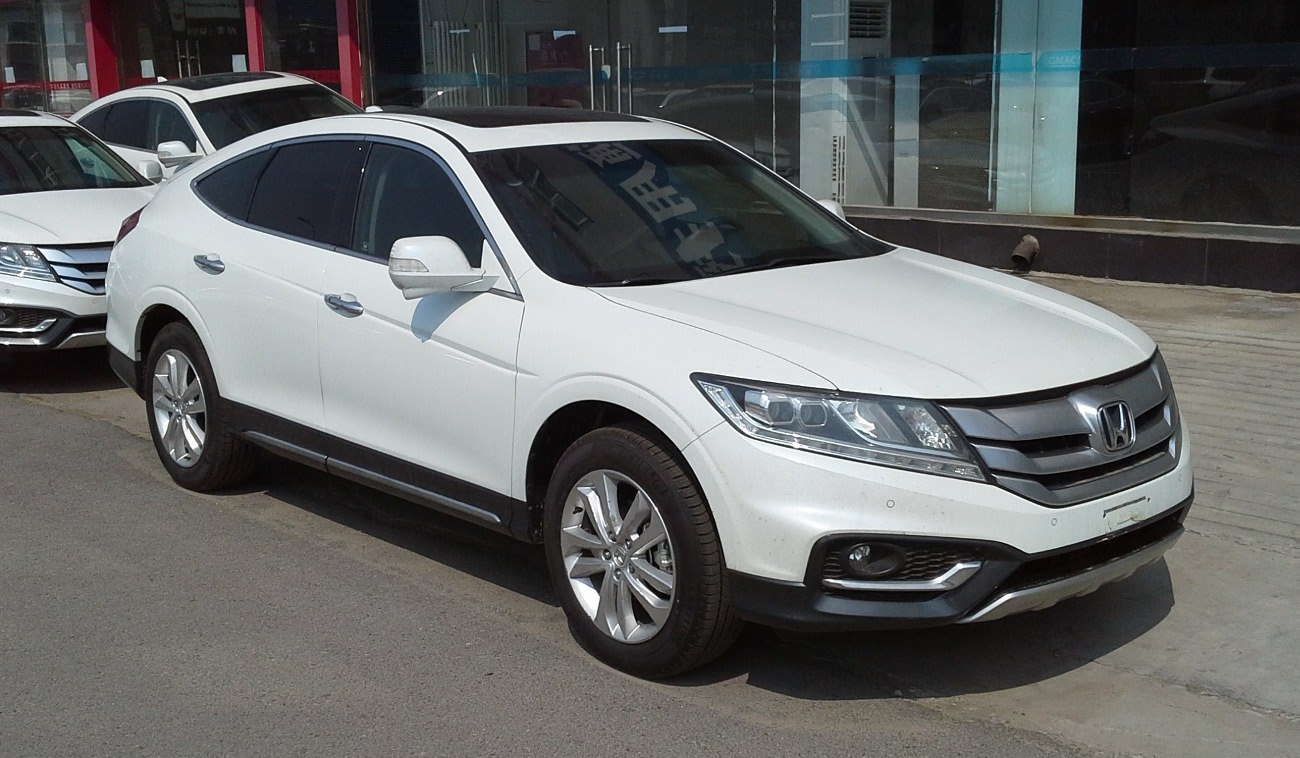 White crossover SUV front-side profile with modern headlights and alloy wheels