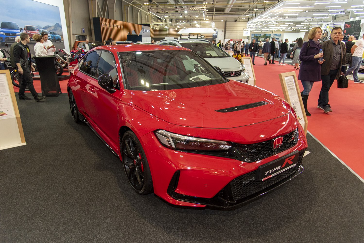Red sports hatchback with aggressive front grille and sporty body kit