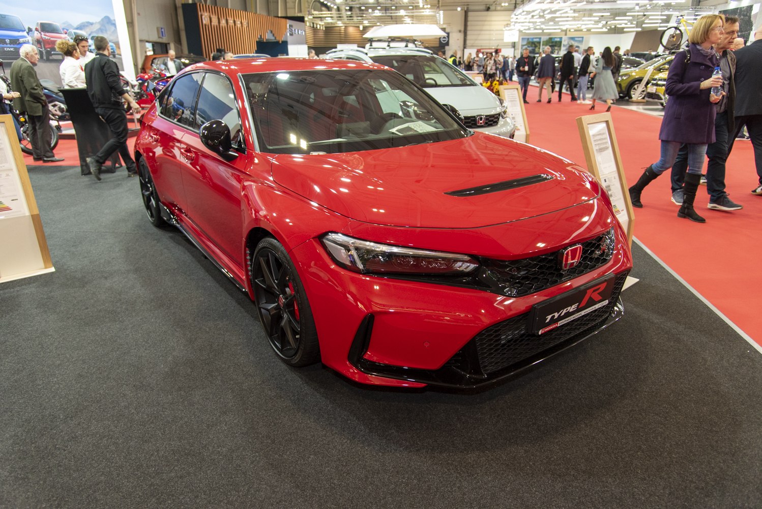 Red sporty front view with aggressive grille and black alloy wheels
