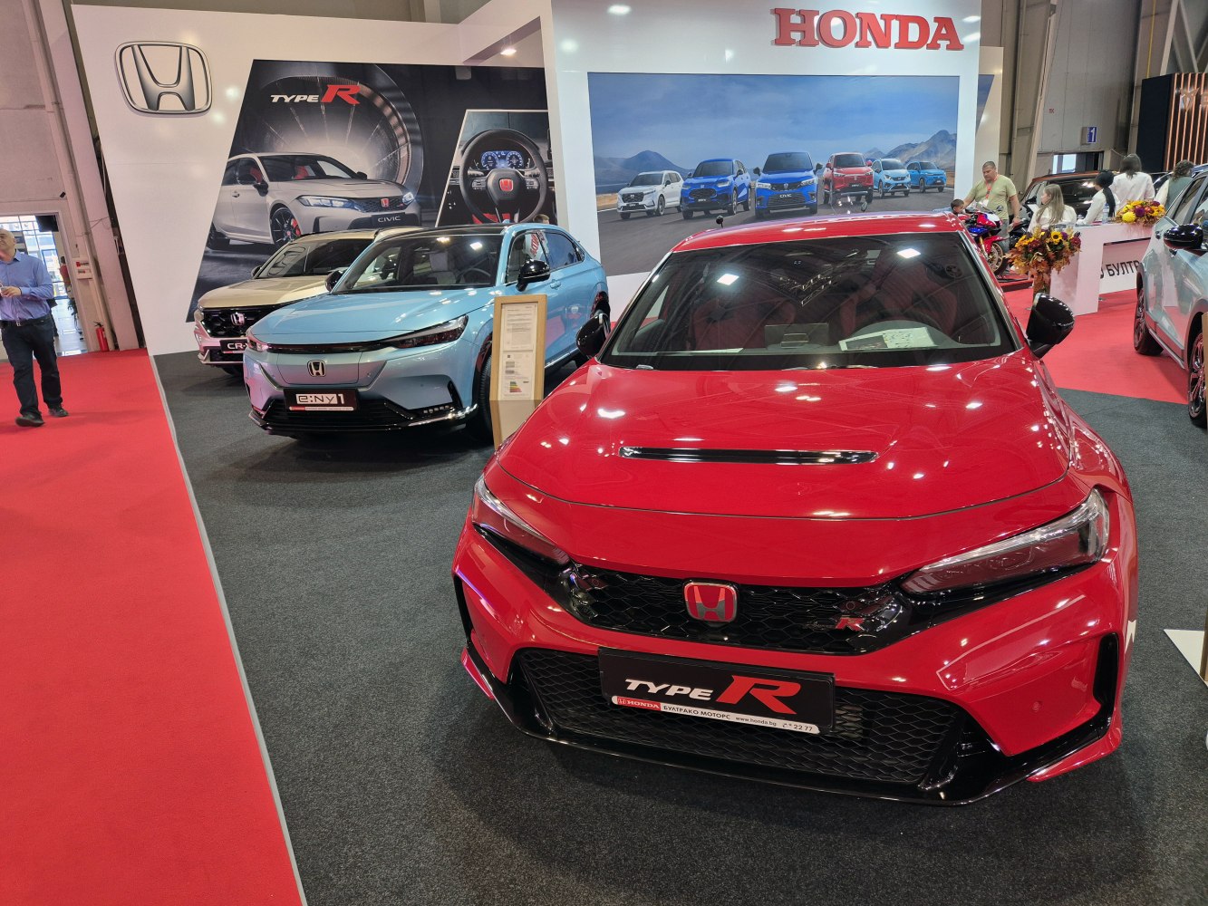 Front view of red sporty hatchback with aggressive grille.