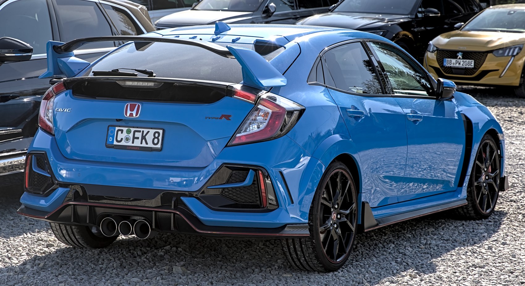 Rear view with large rear wing and triple exhaust system