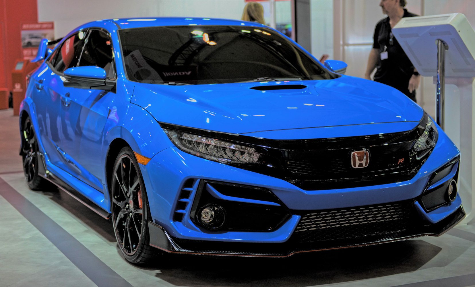 Blue sports hatchback with aggressive front fascia and black alloy wheels