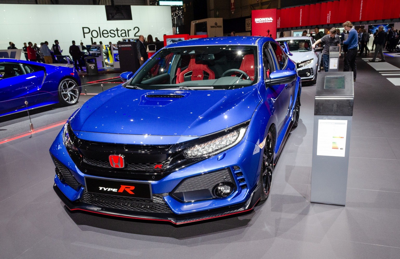 Front view of blue sporty hatch with hood vent and red race seats
