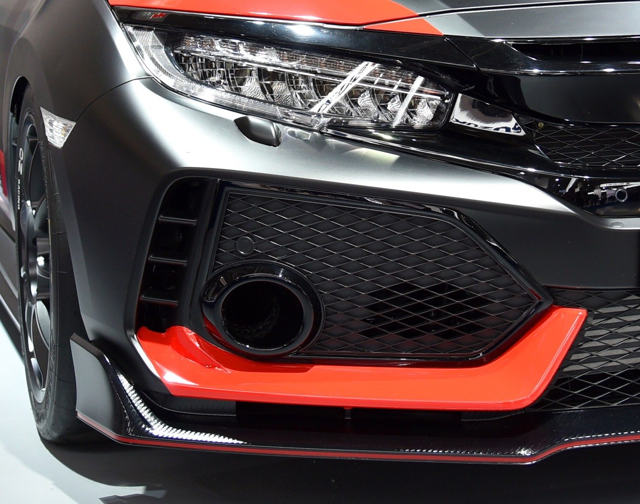 Close-up of front bumper, mesh grille, and headlight