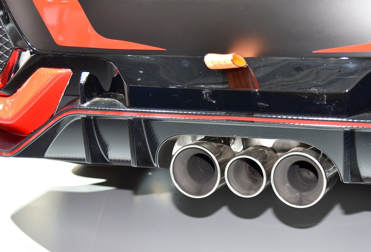 Triple exhaust tips and rear diffuser with carbon fiber fins and sporty design