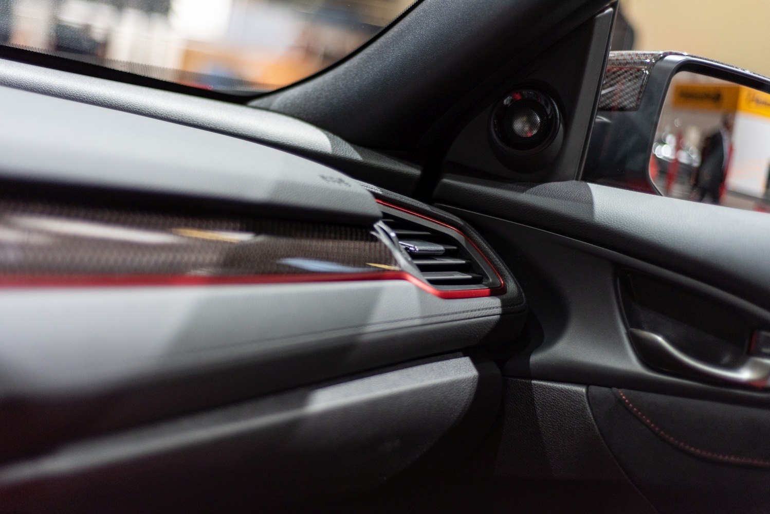 Dashboard air vent with red trim and carbon fiber detailing