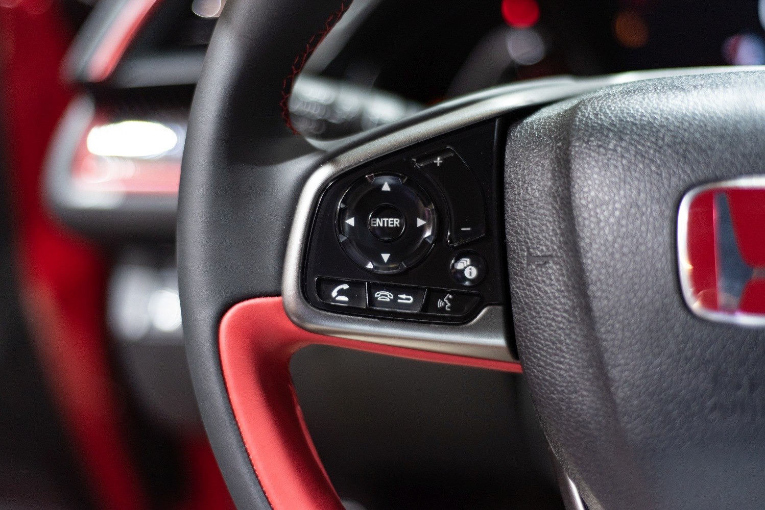 Close-up of steering wheel control buttons and volume controls