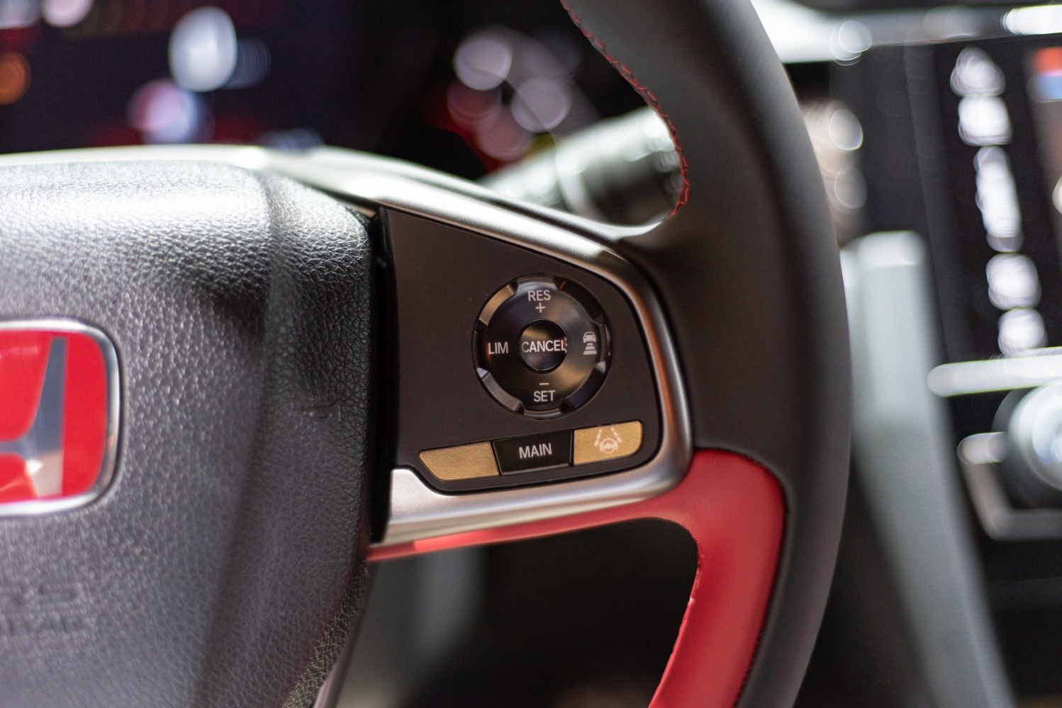 Steering wheel with cruise control buttons and red stitching