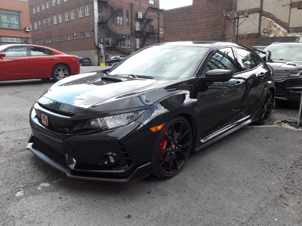 Black sporty hatchback with aggressive front fascia and large rear spoiler