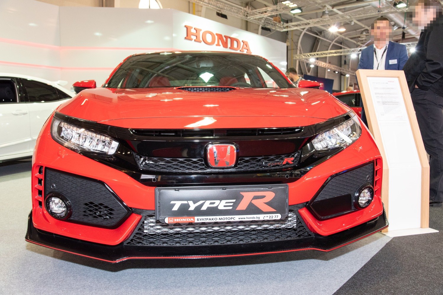 Aggressive front grille and LED headlights of a sporty red performance hatchback