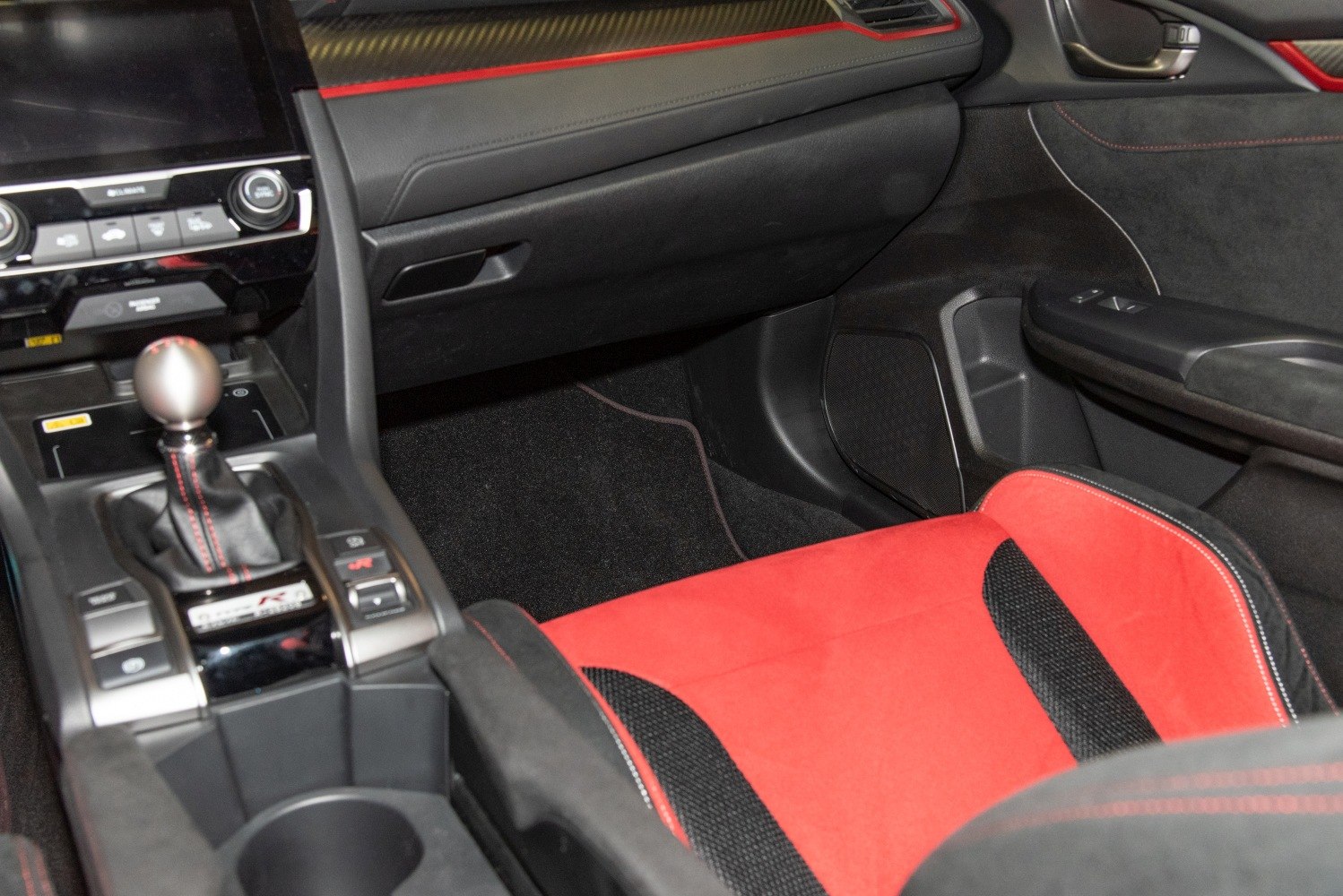 Manual gear shifter and red sport racing seat upholstery