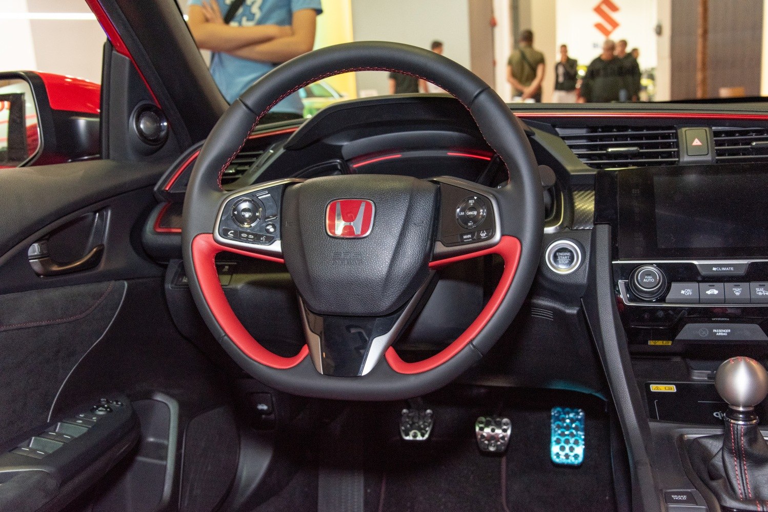 Steering wheel with red accents and interior driving controls.
