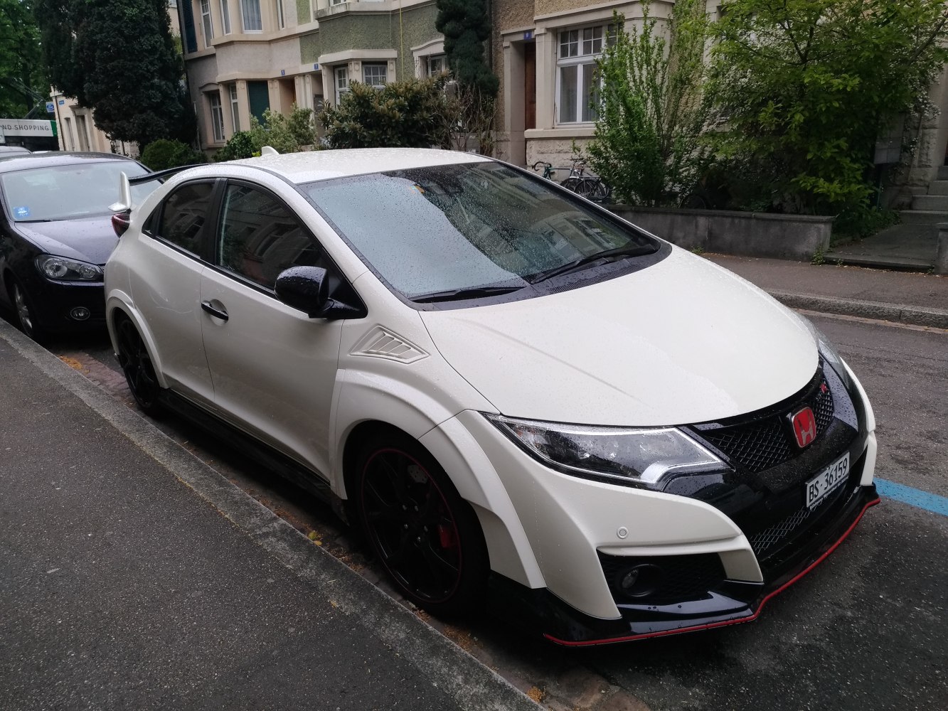 Aggressive aerodynamic front fascia and side body details of a hatchback.
