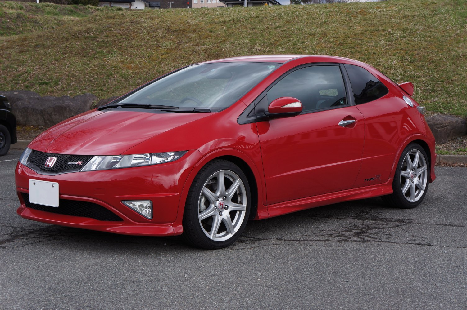 Red sporty compact hatchback with alloy wheels and rear spoiler