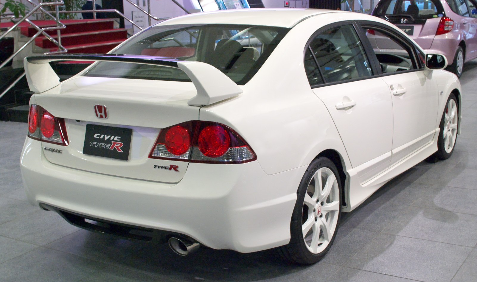 Rear view of white sports sedan with large spoiler and distinctive taillights