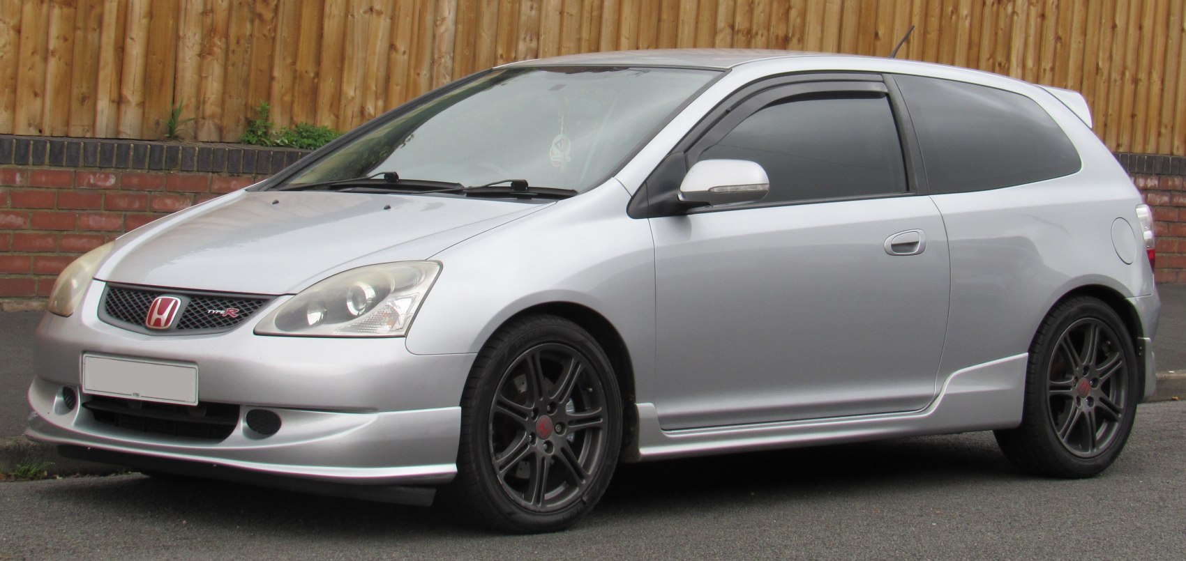 Silver sporty hatchback with black wheels and tinted windows
