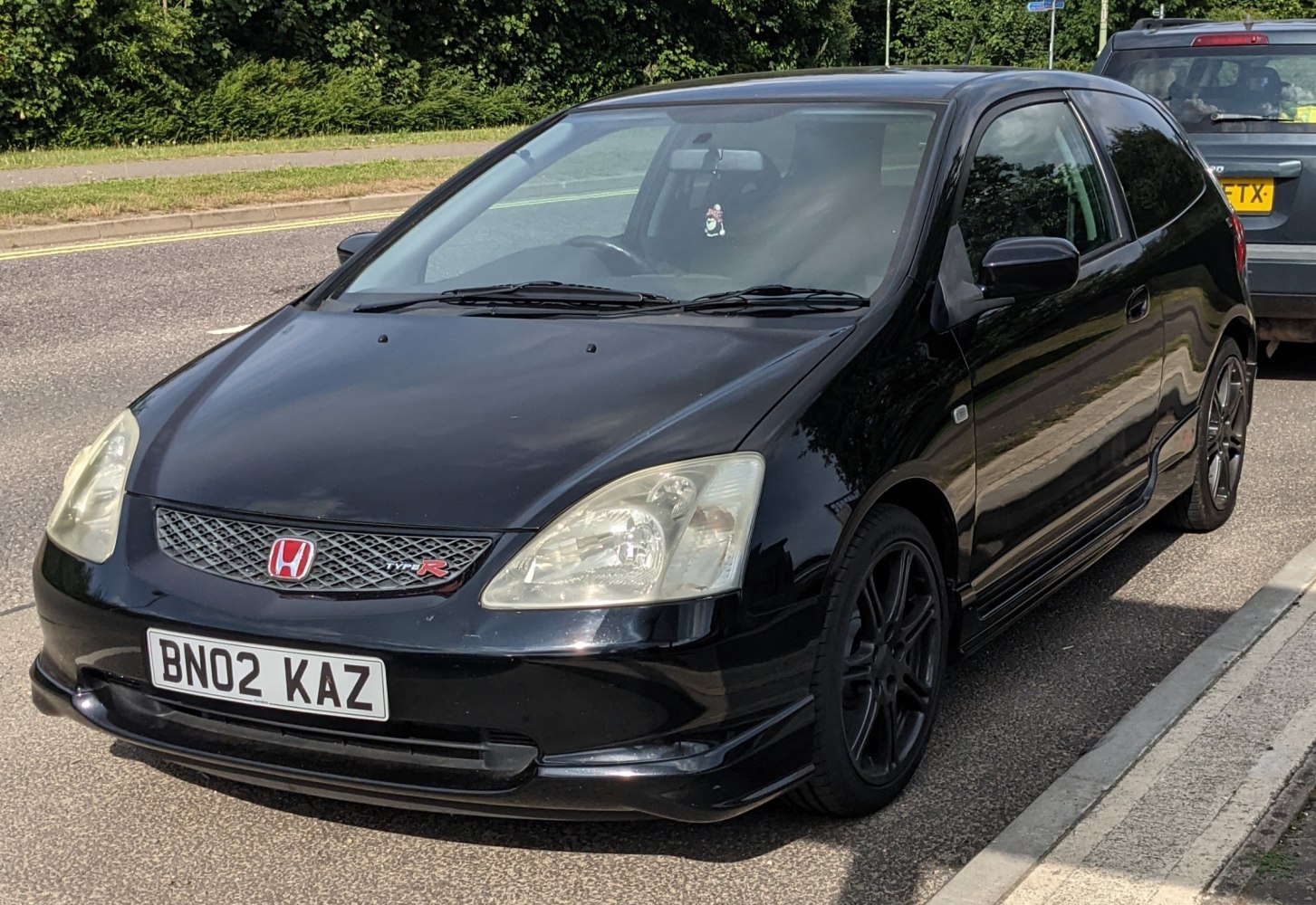 Black sporty hatchback with front grille and alloy wheels
