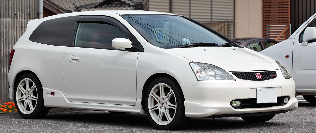 White sport compact hatchback with front grille and alloy wheels