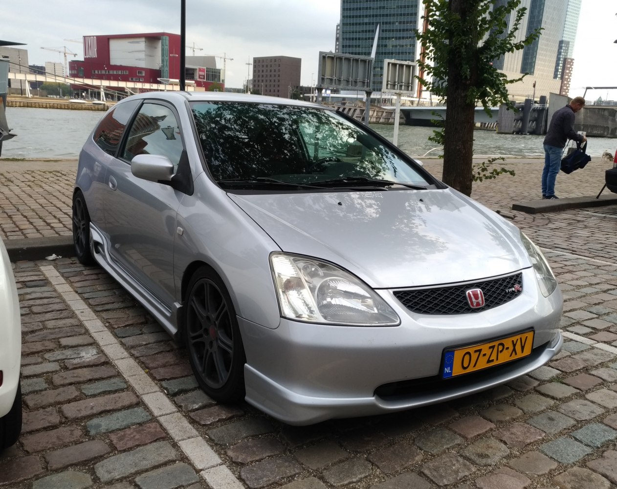 Silver hatchback with sporty wheels and distinctive grille.
