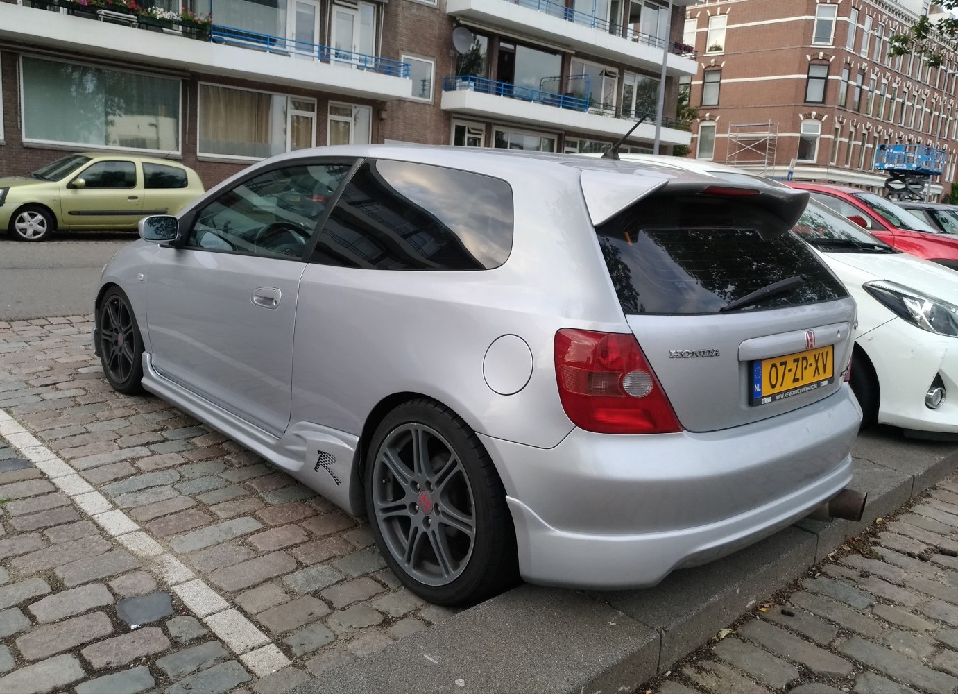 Rear and side view of hatchback with rear spoiler and alloy wheels