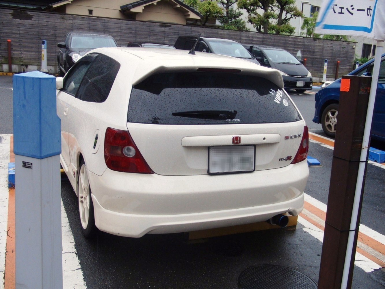 Rear view with spoiler, tinted window, and sporty exhaust tip