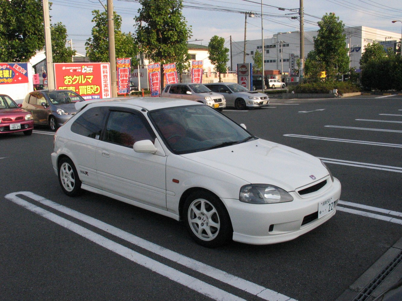 White sporty compact hatchback with three-door layout and alloy wheels