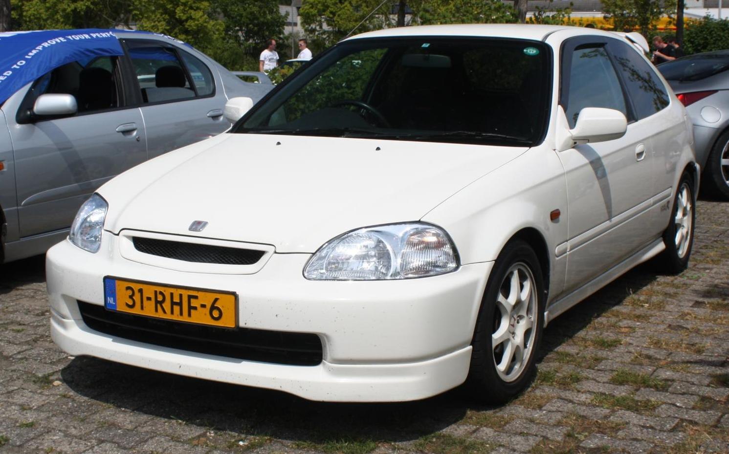 Front side view of white sporty hatchback with alloy wheels