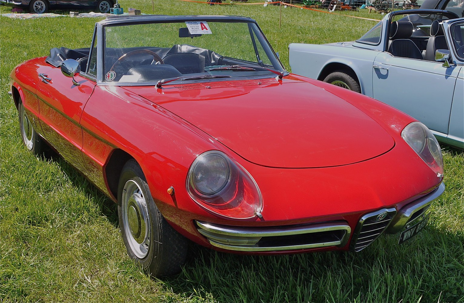 Vintage convertible with rounded headlights and chrome bumper