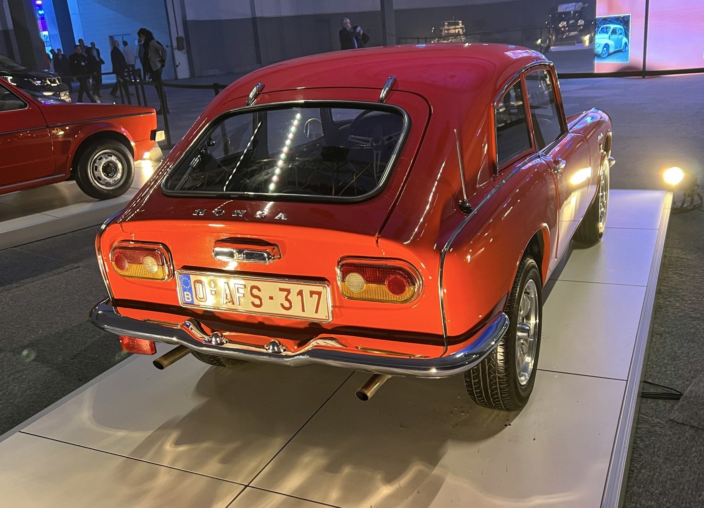 Rear view of a classic car with rounded taillights and dual exhaust pipes