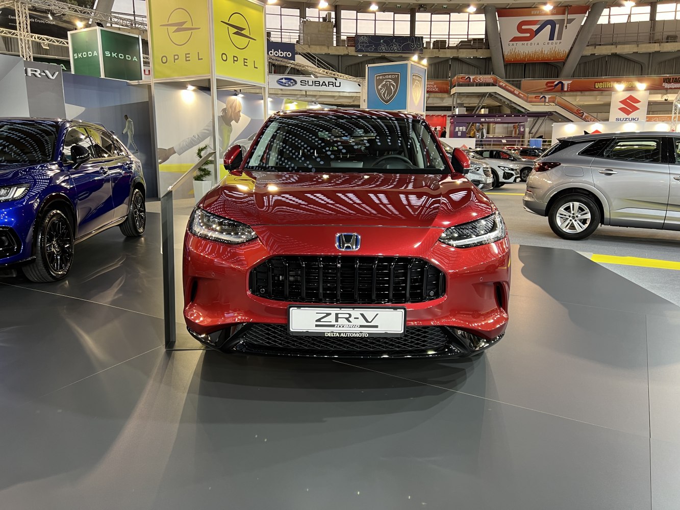 Front view of red SUV with black grille and LED headlights