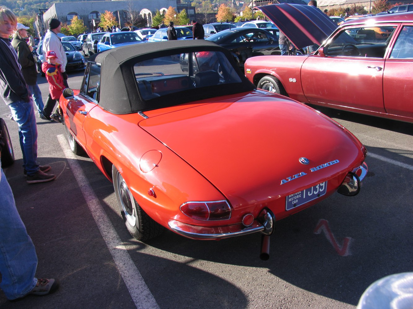 Rear view of classic red convertible with black soft top and rounded taillights