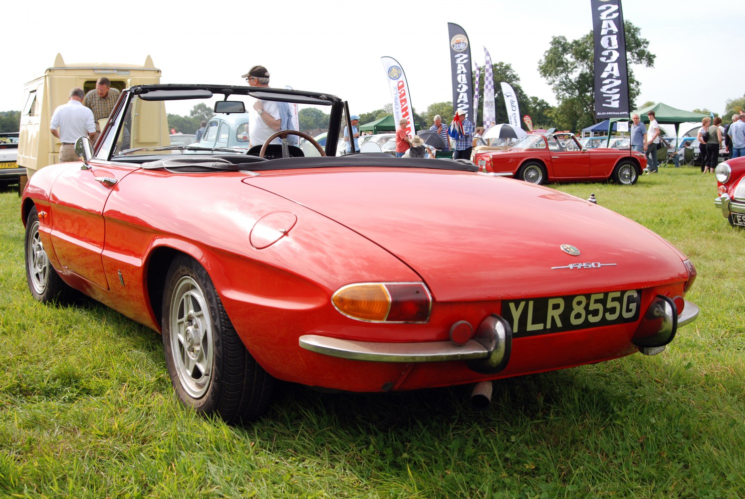 Red classic convertible rear with vintage taillights and chrome bumper