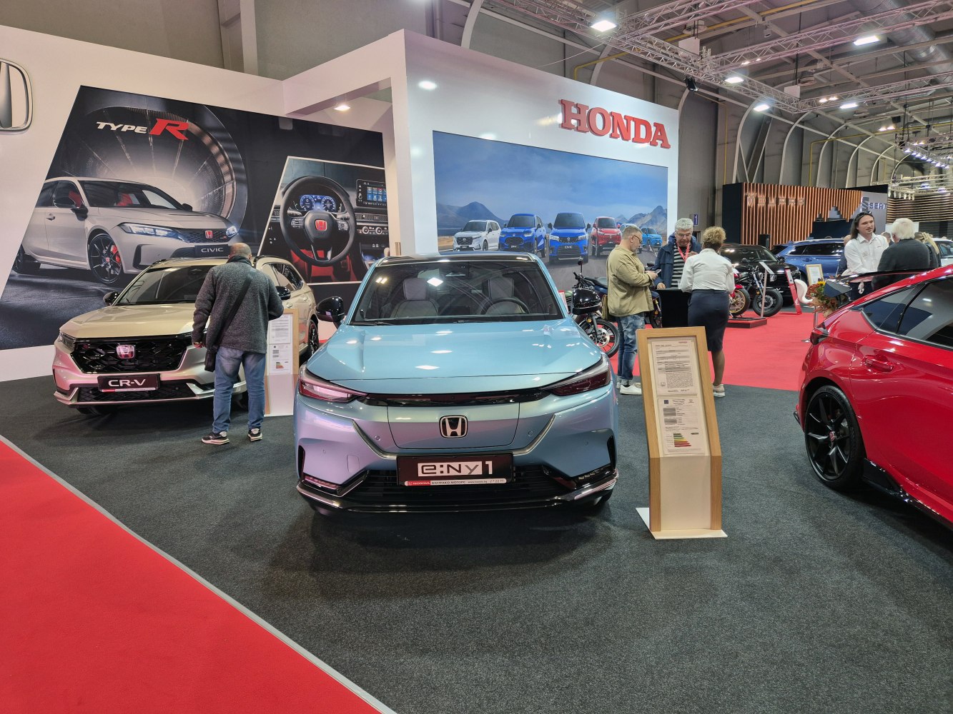 Front view of an electric hatchback with sleek LED headlights and futuristic design