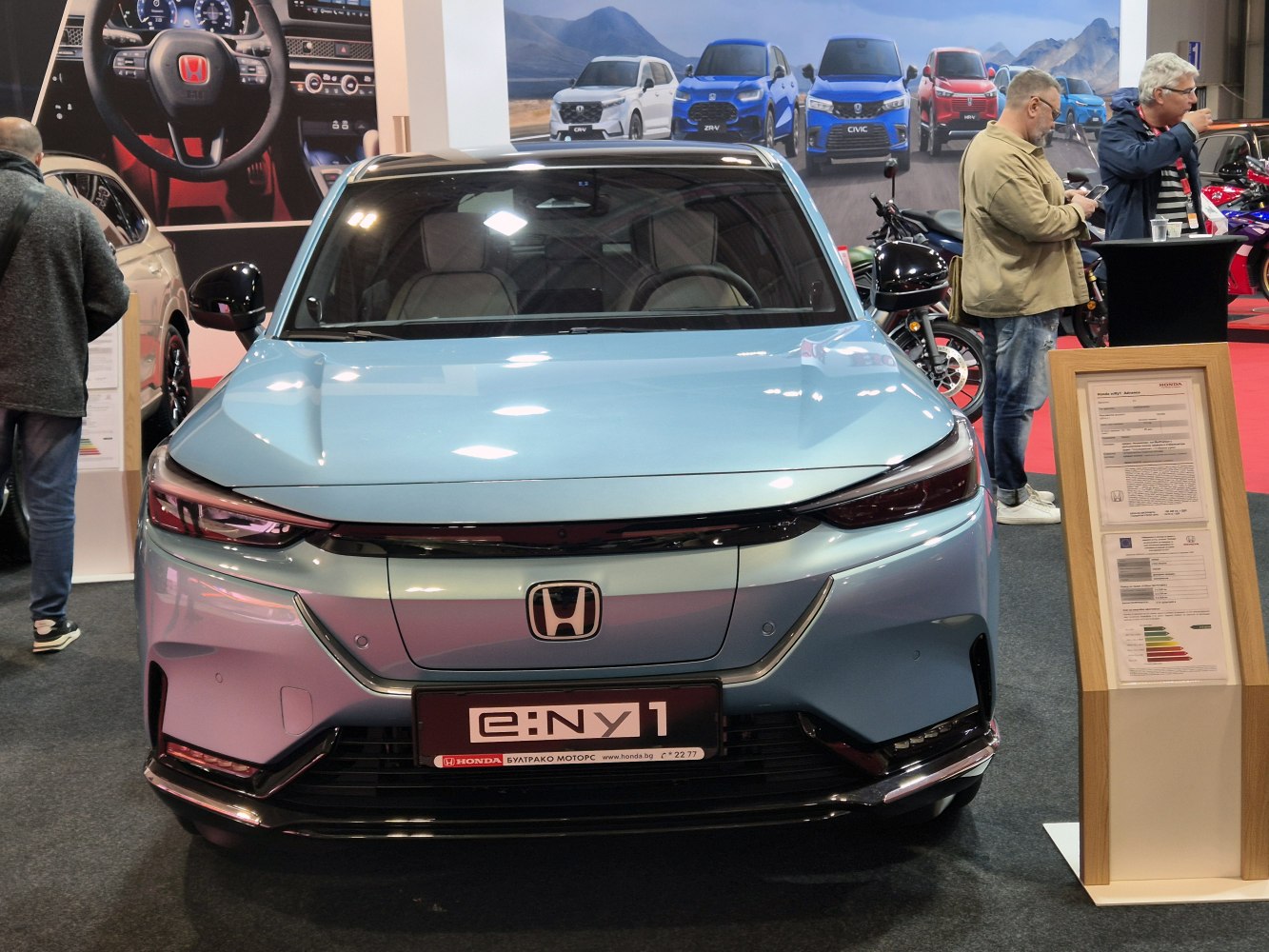 Front view of electric compact car with sleek LED headlights and streamlined design.
