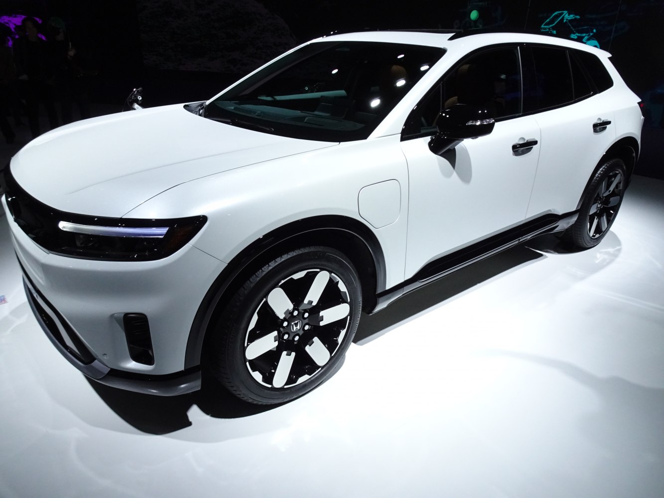 Modern electric SUV with sleek LED headlights and unique black-and-white wheels