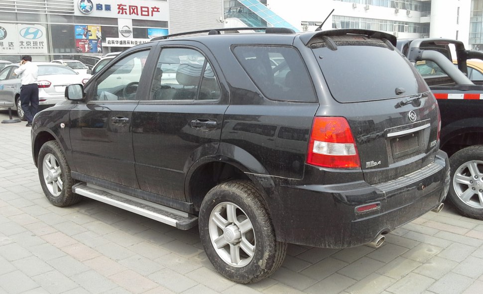 Rear side view of black SUV with roof rails and off-road tires
