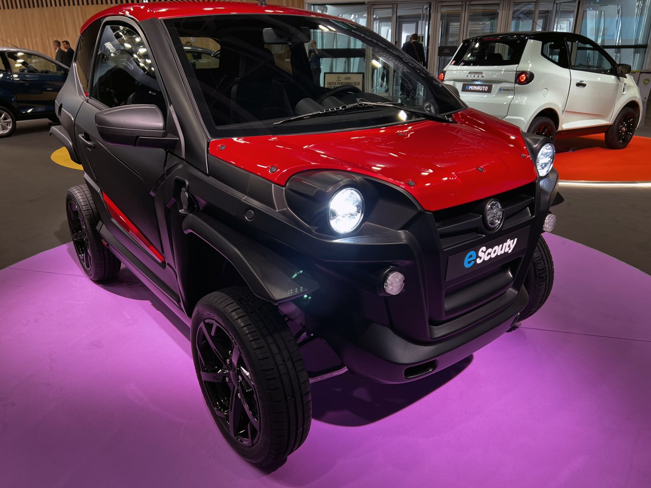 Compact electric vehicle front with round headlights and sporty design