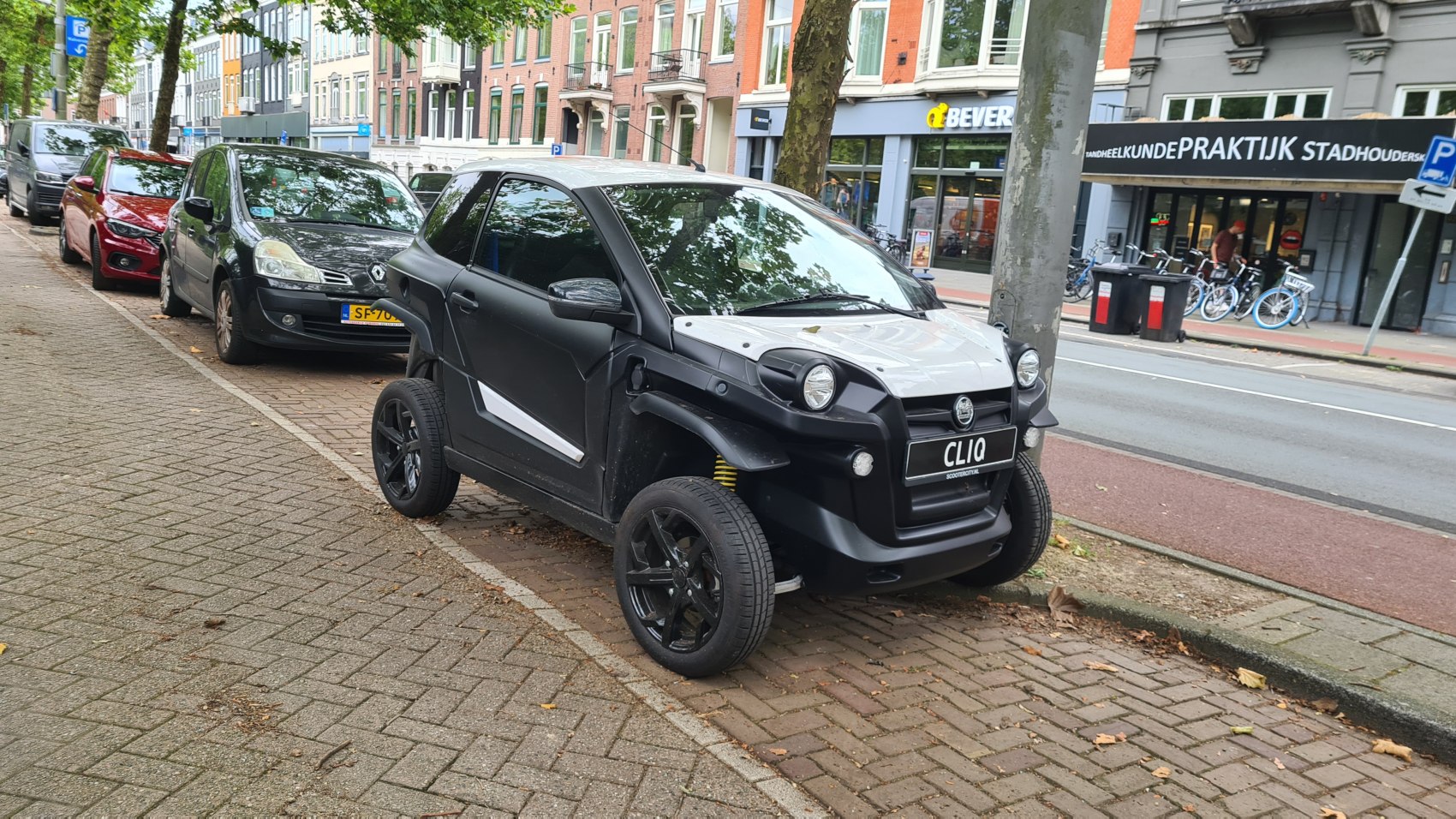 Compact electric urban vehicle with exposed suspension and two-tone body