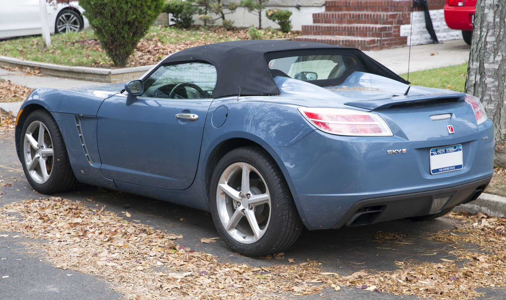 Convertible roadster with black soft top and rear spoiler