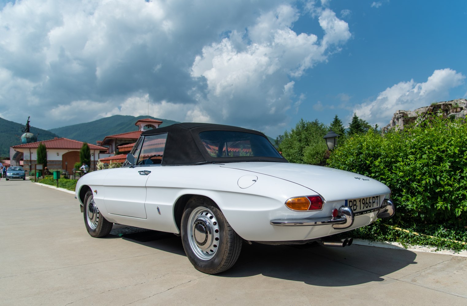 White convertible with black soft top and chrome bumpers.
