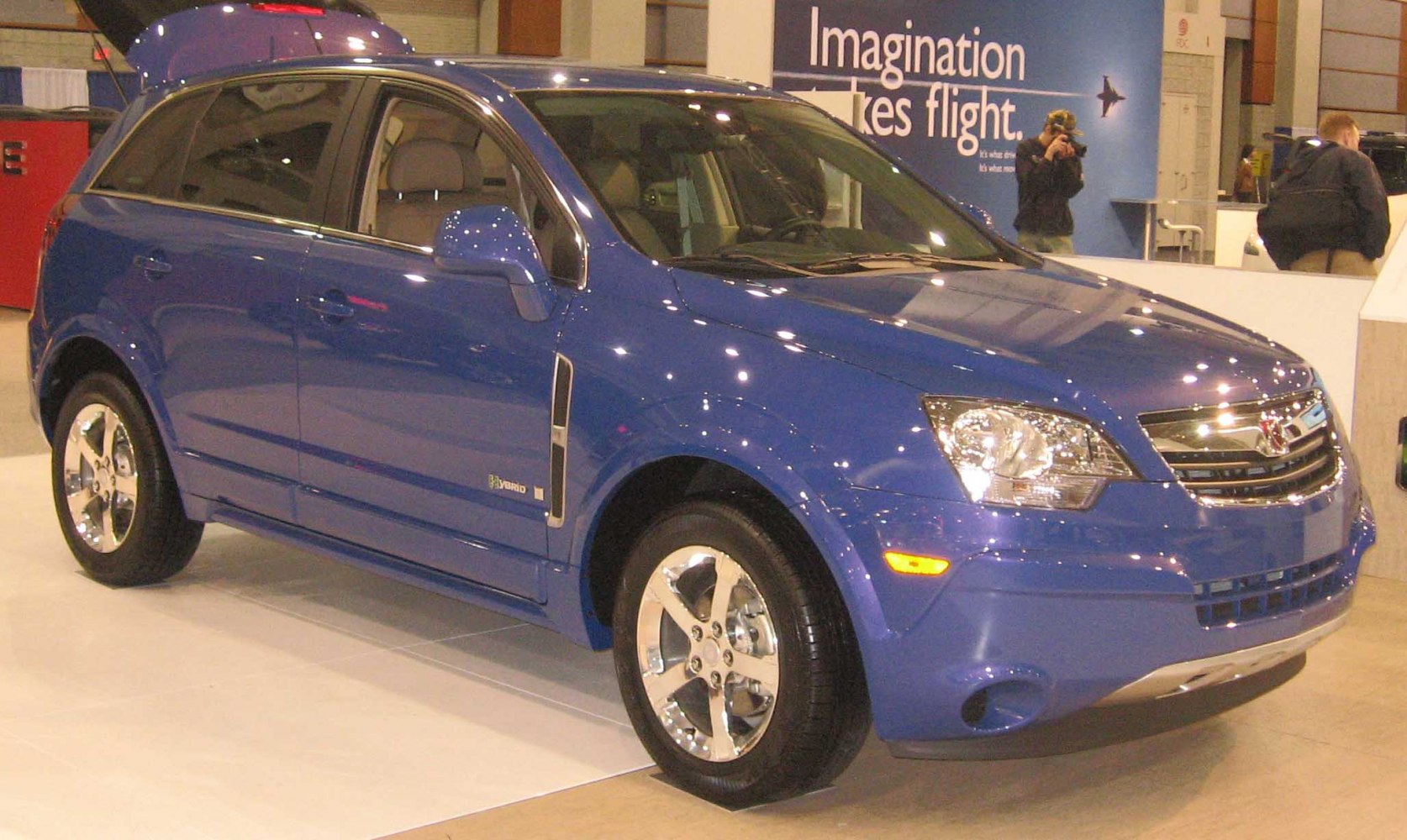 Blue hybrid SUV with chrome wheels and modern headlights.