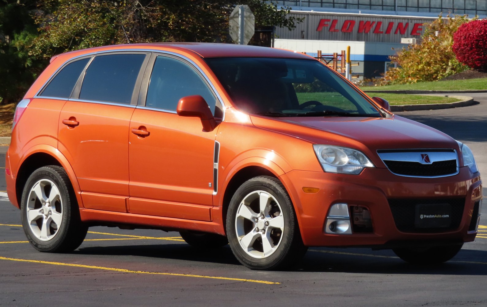 Orange midsize SUV front side view with alloy wheels and distinctive headlights