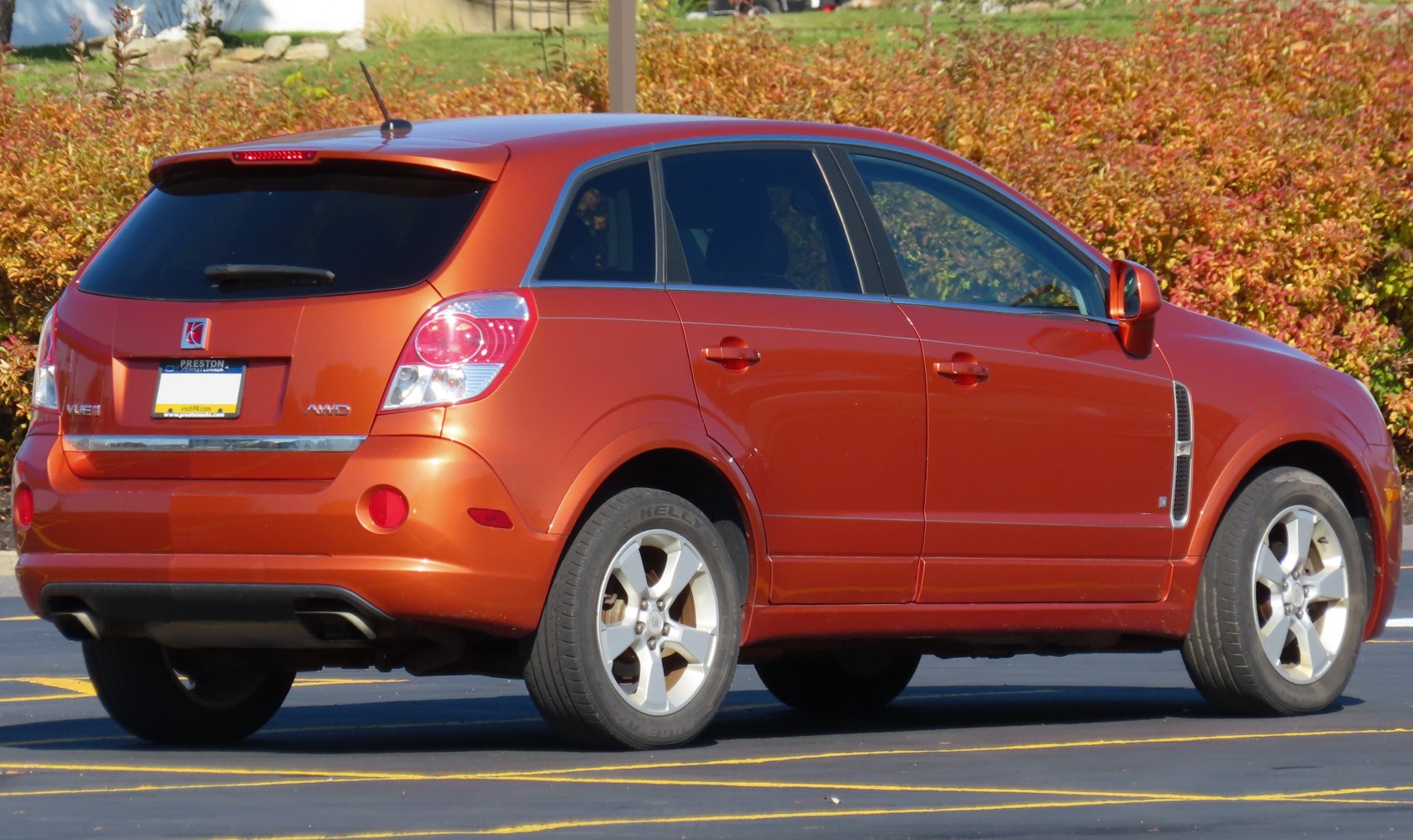Rear and side view of an orange SUV with AWD badge and alloy wheels