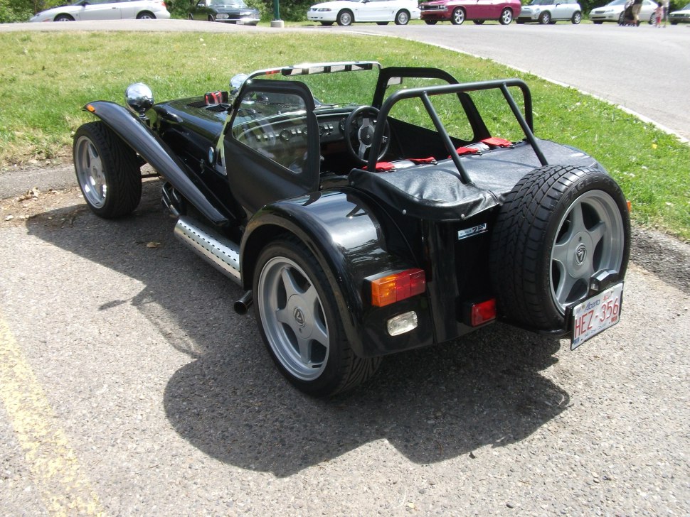 Open cockpit roadster with rear spare tire and side exhaust pipes