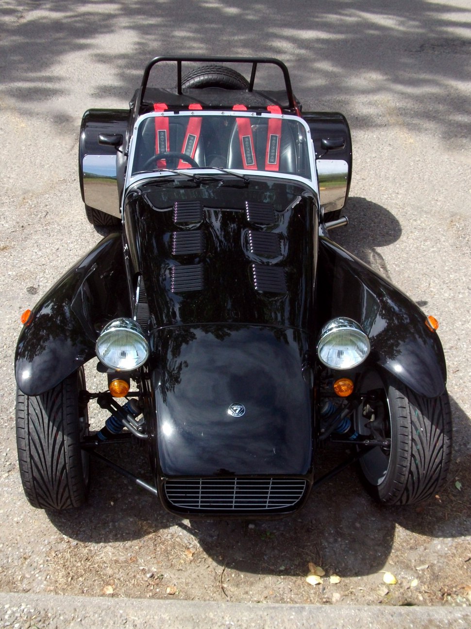 Open-top sports car with hood vents and racing harness seats