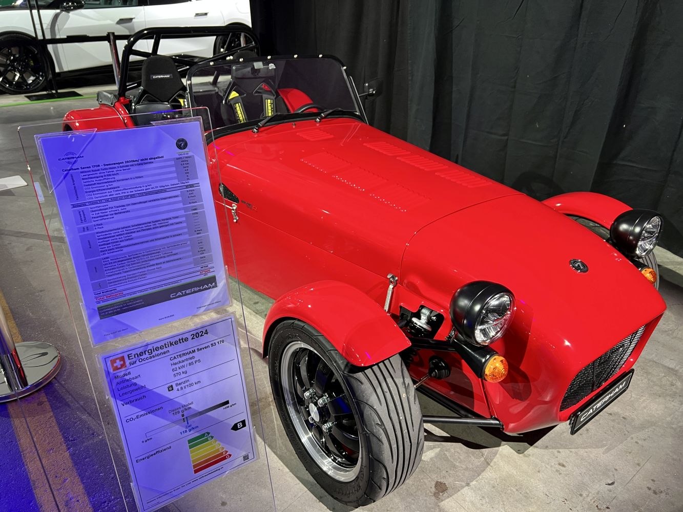 Red open-top sports roadster with exposed front wheels and minimalistic design