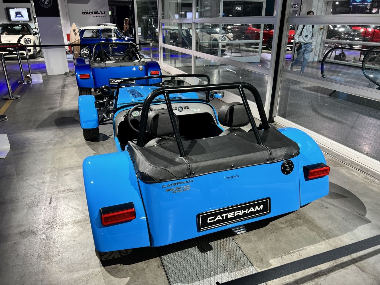 Rear view of blue roadster with open-top and roll bars